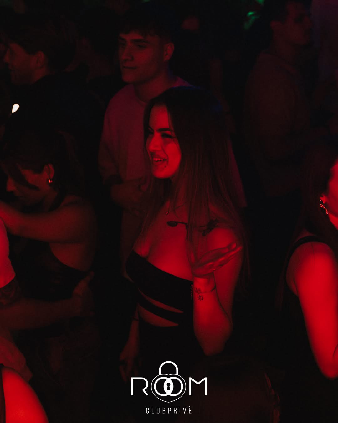 Una ragazza sorridente in pista, immersa nella luce rossa.